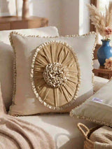 A lifestyle view of the Florence Frieze cushion styled on a beige sofa next to dried pampas grass.