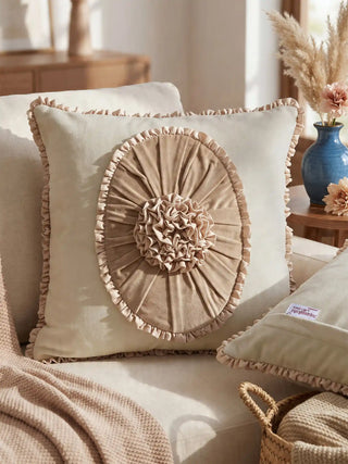A lifestyle view of the Florence Frieze cushion styled on a beige sofa next to dried pampas grass.