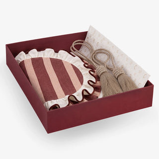 Florentine gift set in an open maroon box — a maroon and blush striped scalloped mat with ruffled ivory edging, beside a gold rope tieback with a full tassel