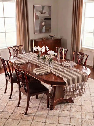 Florentine Ruffles table runner in beige and mocha styled as a complete table scheme on a mahogany Chippendale dining table with matching round ruffled placemats, crystal glasses, ivory taper candles, and white orchids