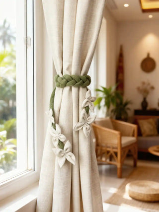 Beige curtains with floret braid tiebacks in a room with furniture and decor.