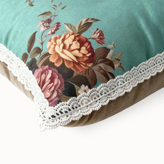 Close-up of the aqua cushion corner showing the detailed white lace trim and floral print.