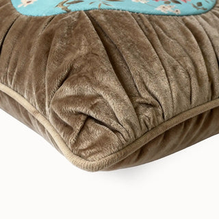 Close-up of the tawny brown ruched velvet texture and piping on the cushion.