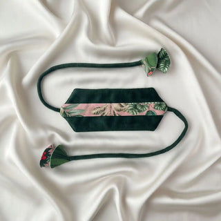Flat lay of the Forest Muse Tieback showing the geometric velvet panel and the long cords with leaf-shaped fabric charms.