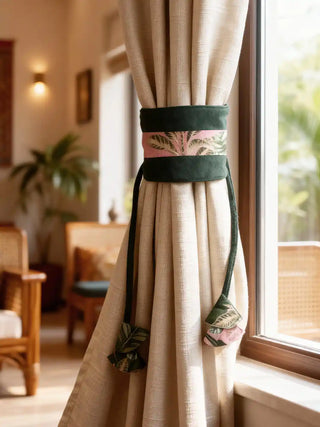 Beige curtain with decorative forest muse tieback in a room with wooden furniture and plants.