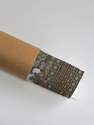 The French Life wall art print partly unrolled from its shipping tube, showing a tonal foliage panel beside a striped rosette border in grey, black and brown.
