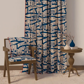 The French Town Pipin curtain styled in a room with a chair and table, demonstrating its unique character and how it complements home decor.

