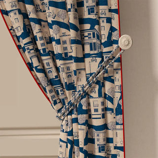 A close-up of the French Town Pipin curtain tied back, highlighting its crisp red piped edge and the elegant drape of the fabric.