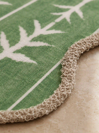 Detailed texture shot of Garden Gala mats revealing the hand-printed leaf motif weave and intricately woven cream scalloped trim.