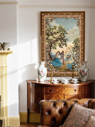 Garden of Tunes European landscape mural styled above a brown leather Chesterfield sofa in a luxury library.