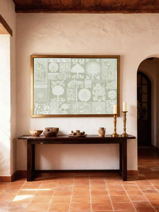 The Geet Madhubani wall art in a gold frame styled above a dark wood console table with artisanal clay vessels in a rustic luxury foyer.