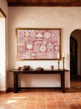 Geet Madhubani wall art in terracotta and white, framed in antique gold above a dark wood console with earthen bowls and brass candlesticks in a terracotta-tiled foyer.