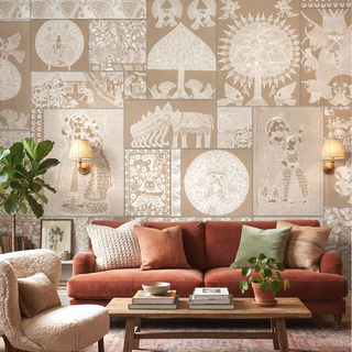 A luxury living room featuring the Geet Madhubani wallpaper in clay beige behind a terracotta velvet sofa and a bouclé accent chair.