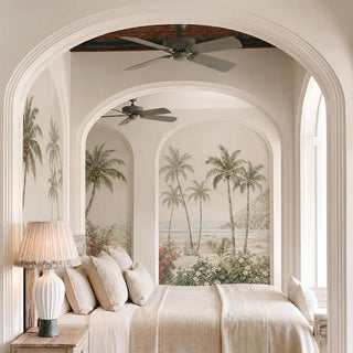 The Goa Coastal Romance coastal palm wallpaper mural dressing a bedroom wall behind a rustic white poster bed.