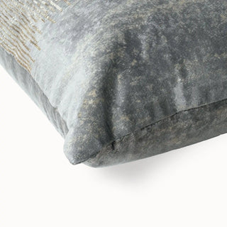 Close-up of the crushed grey velvet texture and piping on the cushion corner.