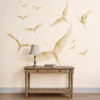 A wall view of the Golden Wings Wallpaper, showing multiple winged motifs arranged in a graceful, floating pattern.