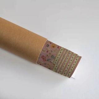 The Golestan Garden wall art print partially unrolled from its kraft paper shipping tube, showing the floral trellis pattern and border.