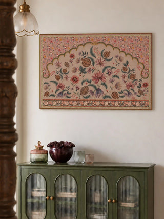 The Golestan wall art in a slim gold frame above a green sideboard with arched ribbed-glass doors, a plum ruffled bowl and glass jars.