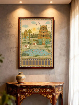 A framed Gopuram temple mural displayed in a contemporary foyer above a rustic carved console table.