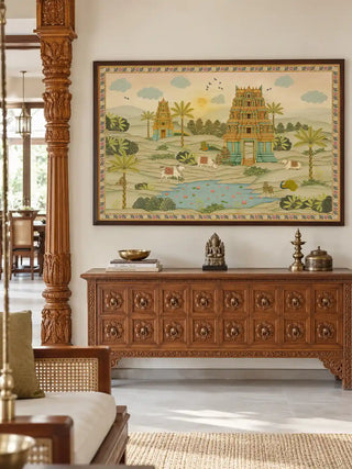 The framed Gopuram wall art displayed above a carved wooden console table beside a traditional pillared entryway.