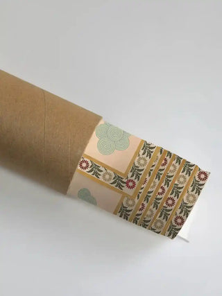 Gopuram wall art print in sandstone and jade rolled in a kraft shipping tube, showing the floral border and swirled cloud motif.