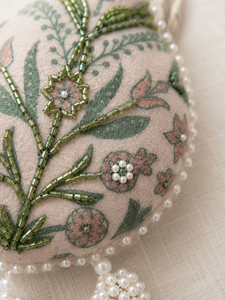 A high-resolution close-up of the green glass bugle beads, pink printed blossoms, and white seed pearls on the Gulbano curtain tie back.