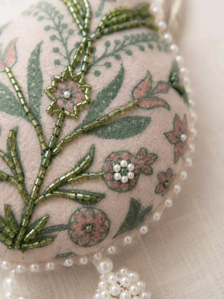 A high-resolution close-up of the green glass bugle beads, pink printed blossoms, and white seed pearls on the Gulbano curtain tie back.