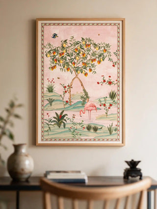 The Gulbiya Chinoiserie wall art in Blush Pink, framed and hung view-entryway above a dark wood console with a vase and small ornaments.