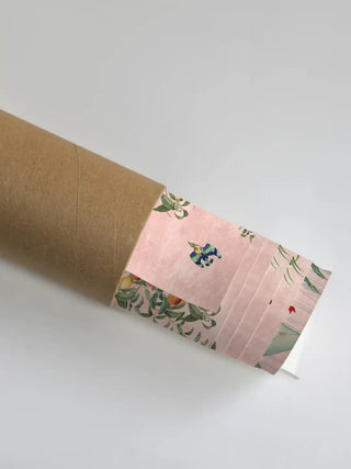 A close-up of the Gulbiya wall art partially unrolled from its premium shipping tube, showcasing the intricate bird and floral texture