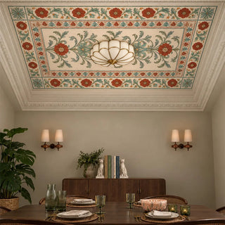 The Gulistan Frieze wallpaper on a panelled dining room ceiling, with red and blue-green blooms framing a scalloped glass ceiling light above a wooden sideboard.