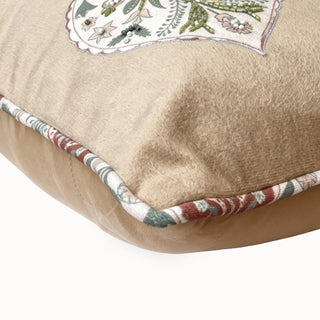 Close-up of the fawn velvet cushion showing the detailed floral embroidery and pattern piping.