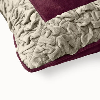 Close-up of the Jhalak cushion showing the intricate texture of the hand-gathered ivory ruffles against maroon velvet.