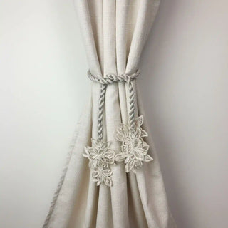 Ethereal Petals Handcrafted Curtain Tieback secured around a textured off-white curtain, demonstrating the decorative floral ends.