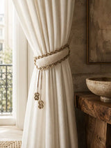 The Hazel Verse padded linen curtain tie back elegantly gathering a full cream drapes panel in a rustic, modern washroom layout.