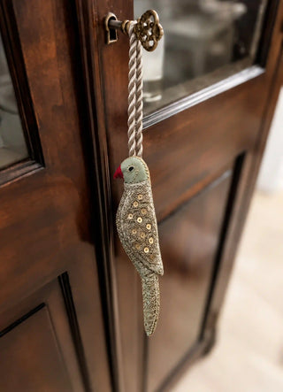 The Heer charm in Sage & Gold, view-cabinetkey hanging from a brass key on a glass-front cabinet.