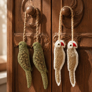Close-up of hand-embroidered sequin and zari detailing on the Heer and Ranjha bird tiebacks hung on a carved wooden cabinet