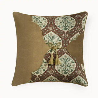 Decorative cushion with intricate pattern and tassel on a white background