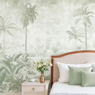 A luxury bedroom featuring the Hidden Grove sage green mural behind a bed with matching sage green cushions.