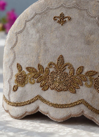 The Hoor tea cosy in Stone, view-detail of the beaded rose garland and fleur-de-lis accent.