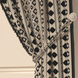 A close-up of the Ikkat Fringes curtain tied back, showing the tasseled tie-back and the pattern on the gathered fabric.