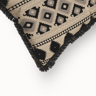 A close-up of the "Ikkat Fringes" cushion cover, highlighting the prominent black fringe and the intricate details of the geometric patterns.
