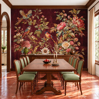 The Imperial Garden wallpaper in burgundy behind a long wooden dining table with sage green chairs, songbirds among peonies above view-dining