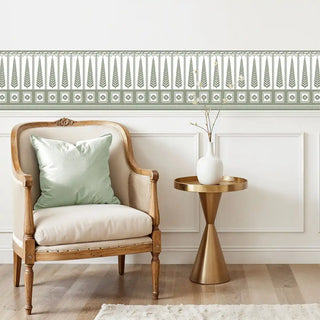 Indigo Grove sage green wall border used as a decorative accent above wainscoting in a room with a classic armchair and gold side table.