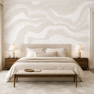 Infinite Flow abstract wallpaper in Ivory Sand as a bedroom feature wall behind an upholstered bed.
