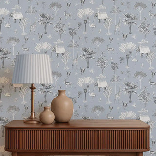 Decorative wallpaper with nature-themed design, wooden console table with lamp and vases against it.