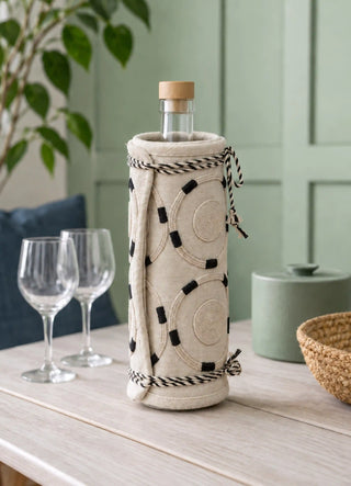 The Ivory Blossoms jug cover in Ivory, view-sideboard wrapped around a corked glass bottle.