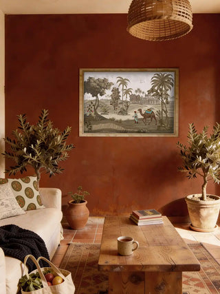Luxury living room with Jaisalmer desert wall art framed on a terracotta-colored wall above a cream sofa and rustic coffee table.