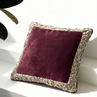 The Jhalak ivory and maroon cushion styled on a minimalist white architectural ledge.
