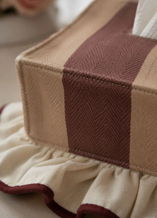 The Juliet tissue case in Wine & Camel, view-detail of the herringbone stripe and ruffled hem.