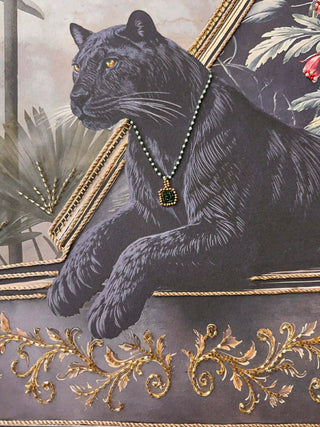 A detailed close-up of the Jungle Noir embroidered wall art highlighting the black panther in a beaded pendant necklace above gold scrollwork.